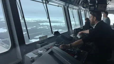 Simon Wallace Pharos captain Simon Wallace on the bridge of the vessel Pharos looking out of the window while navigating through floating ice near South Georgia